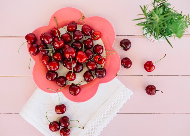 Elevated view of red cherries on flower shaped plate