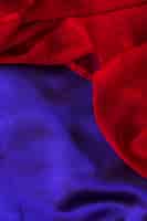 Foto gratuita vista elevata della tessile chiffon rosso su un semplice panno blu