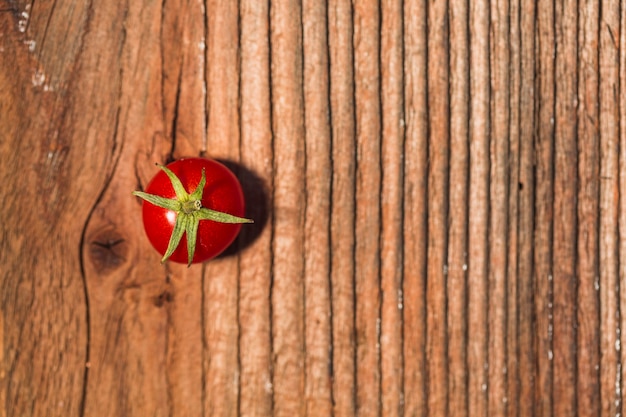 Elevated view of red juicy cherry tomato on wooden background