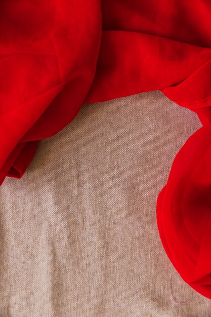 Elevated view of red textile on brown fabric background