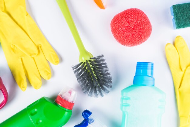 Elevated view of scattered cleaning equipments on grey background