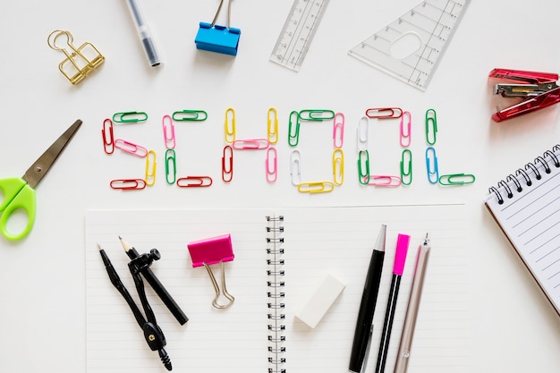 Elevated view of school text with stationeries on white background