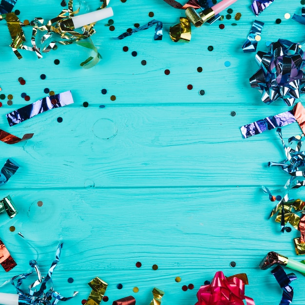 Elevated view of shiny party decoration material over blue desk