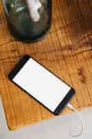 Free photo elevated view of smartphone on wooden desk