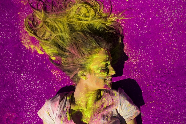 An elevated view of smiling woman covered with holi color powder