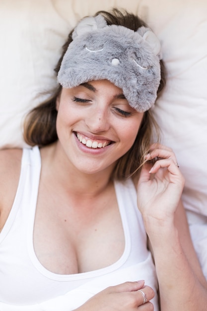 Elevated view of smiling young woman on bed