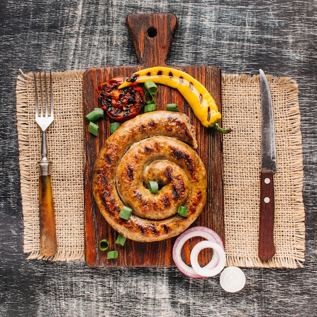 Elevated view of snail sausage on wooden cutting board