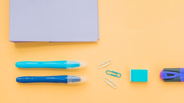 Elevated view of stationery over orange surface