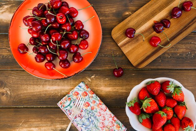 Elevated view of strawberries and cherries on wooden background