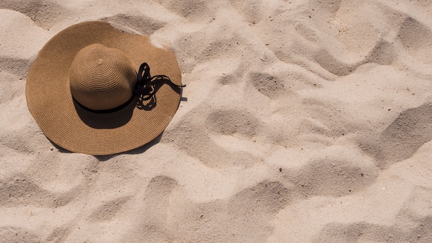 Foto gratuita una vista elevata di sunhat sulla sabbia della spiaggia