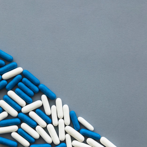 Elevated view of sweet candy capsules on grey background