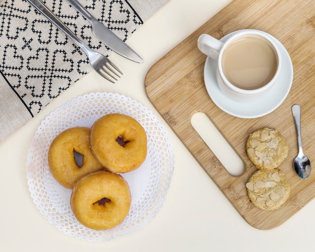 Free photo elevated view of tea with cookies and donuts