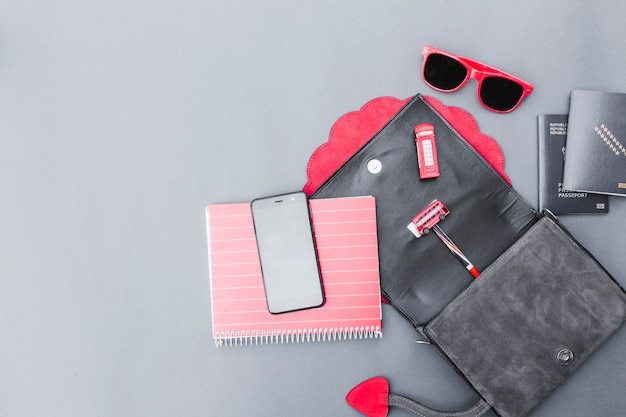 Elevated view of traveler equipment with plastic toys on grey background