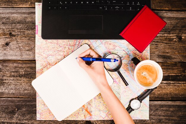 Elevated view of a traveler writing on blank notepad