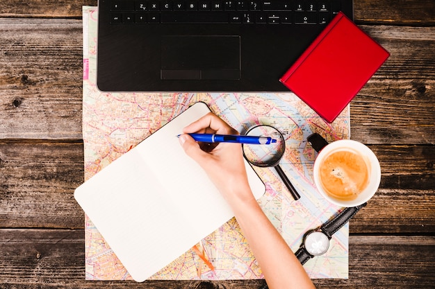 Elevated view of a traveler writing on blank notepad