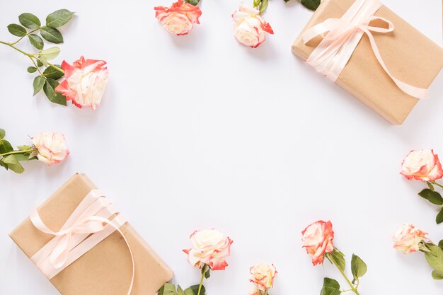Elevated view of two gift boxes and roses on white backdrop