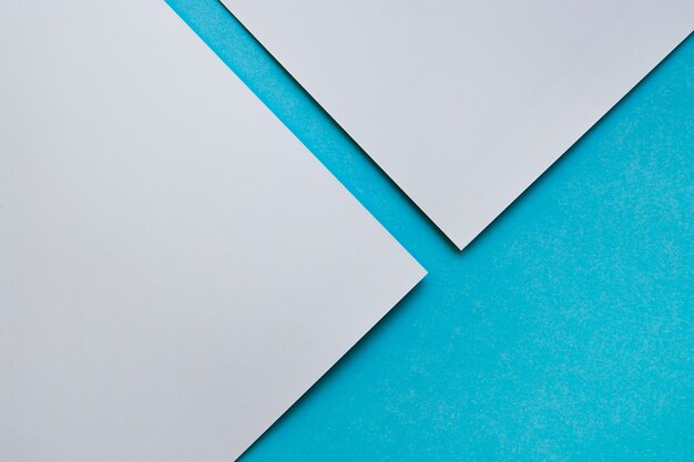 Elevated view of two grey craftpapers on blue background