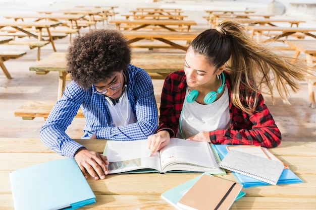 An elevated view of university students reading the books in the classroom