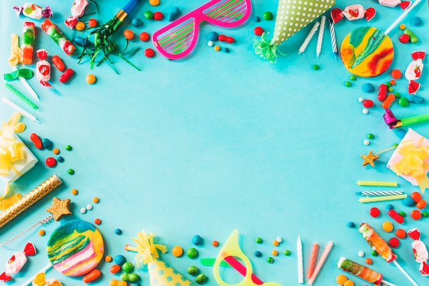 Elevated view of various birthday party accessories on blue background
