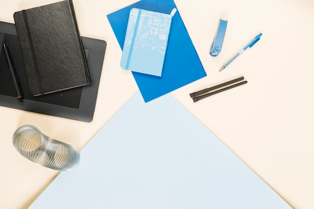 Elevated view of various stationeries on colorful paper background