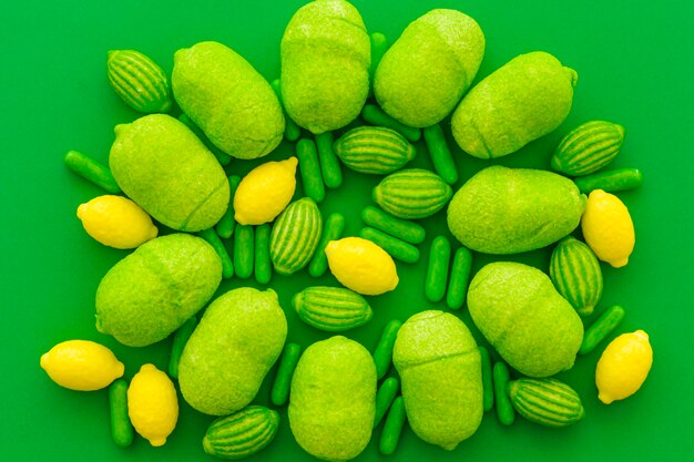 Elevated view of various sweet candies on green surface