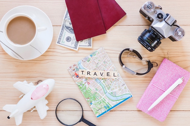 Elevated view of various traveler accessories with tea cup on wooden surface