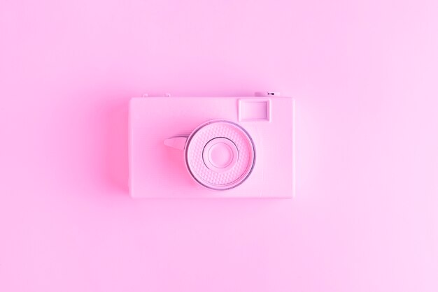 An elevated view of vintage old camera over pink surface