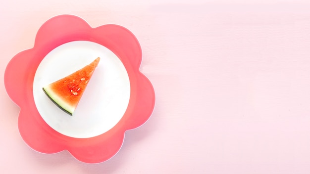 Elevated view of watermelon slice on floral shaped plate