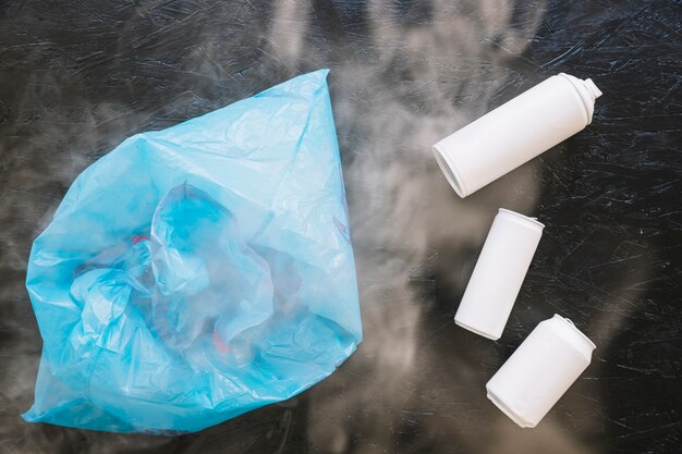 Elevated view of white bottles and plastic bag surrounded by smoke