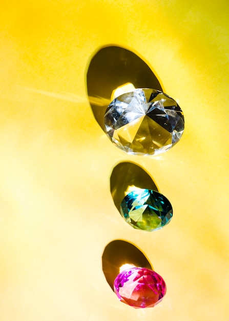 Foto gratuita una vista elevata del bianco; verde; e diamante rosa su sfondo giallo