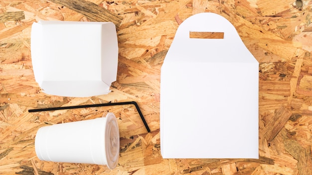 An elevated view of white takeaway food on wooden background