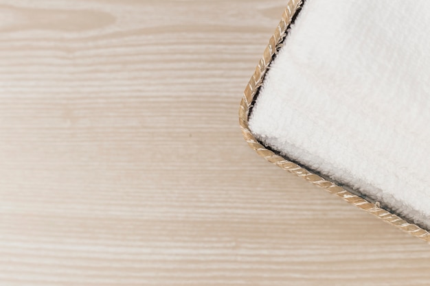 Elevated view of white towel in tray on wooden backdrop