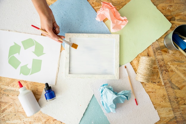 Free photo elevated view of woman's hand painting white paint on mold