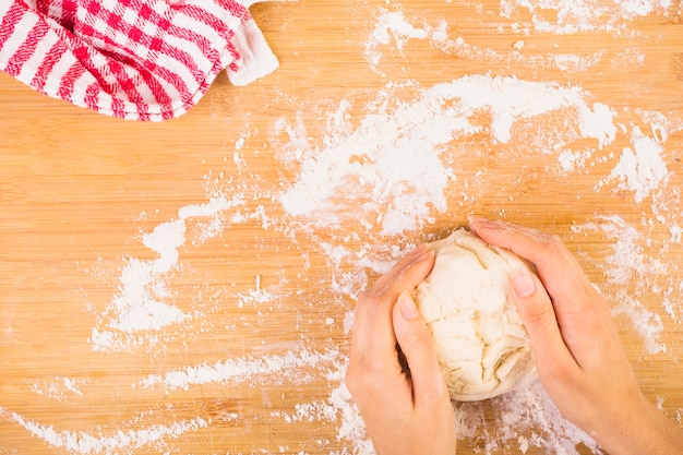 Elevated view of woman's hand preparing dough