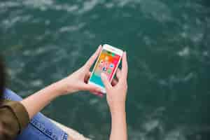 Free photo elevated view of woman using cellphone with social media notifications on screen