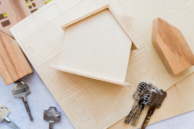 An elevated view of wooden miniature house model with keys