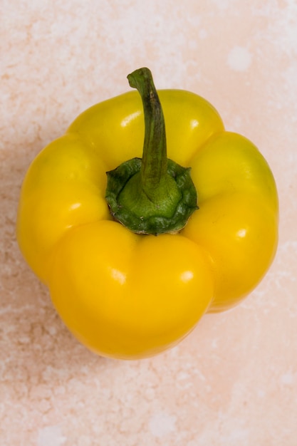 Free photo an elevated view of yellow bell pepper on texture background