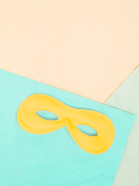 Free photo elevated view of yellow eye mask above colored background