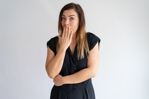 Embarrassed woman covering mouth with hand