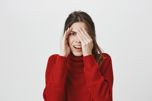 Embarrassed woman peeking at something disgusting