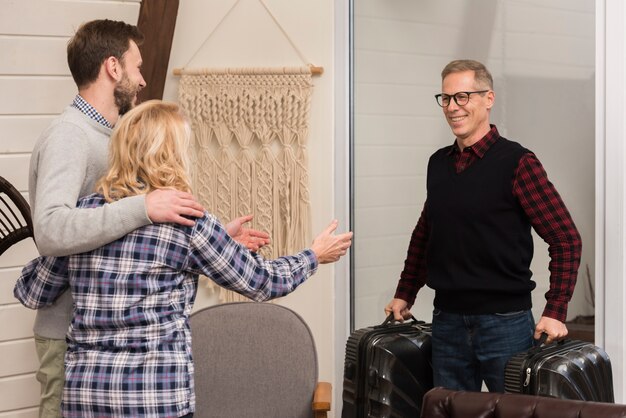 Embraced mother and son with father holding suitcases