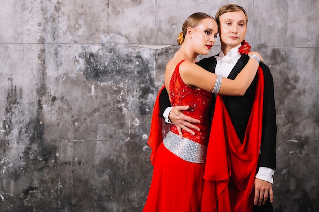 Embracing couple in ballroom suits