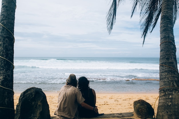 Embracing couple looking at ocean