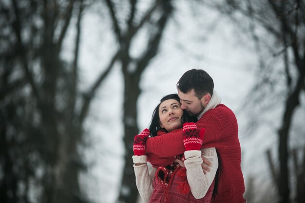 Embracing couple in winter forest