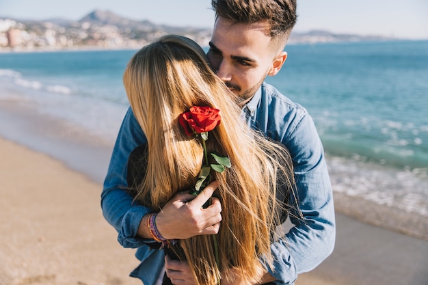 Охватывая романтическую пару с розой