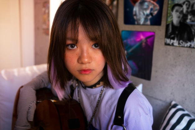 Free photo emo girl holding guitar medium shot