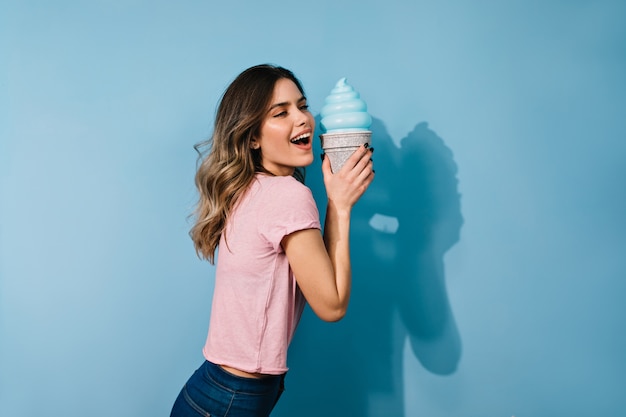 アイスクリームを食べる感情的なブルネットの女性