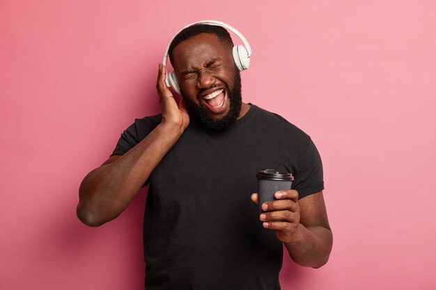 Emotional carefree man dances to favourite song from playlist