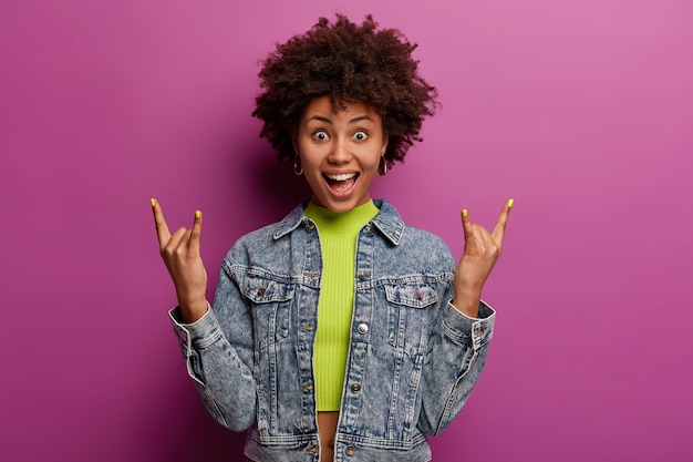 Free photo emotional curly woman visits music festival, reacts on favourite song