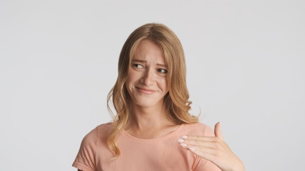 Emotional funny blond girl showing no gesture over gray background. Face expression